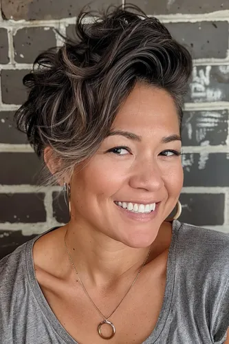 Try on this stylish short wavy hairstyle with elegantly tousled layers that add volume and texture. The hair is highlighted with shades of brown and blonde, creating a vibrant and dynamic look.