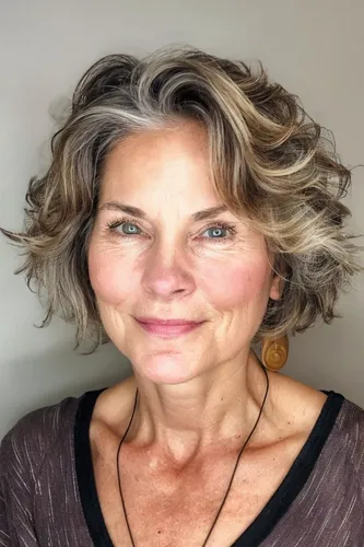 Try on this elegant short curly hairstyle with gray and blond highlights swirled through. The curls are soft and voluminous, adding a playful yet sophisticated touch.