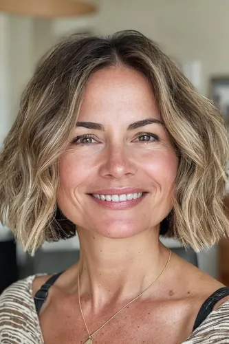 Try on a wavy bob hairstyle. This style features layered waves that add volume and texture, complementing a relaxed yet chic look.