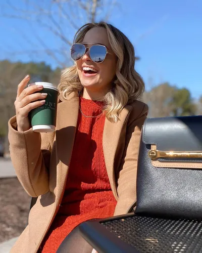 try on a short, wavy hairstyle with highlighted tones, wearing sunglasses and smiling outdoors
