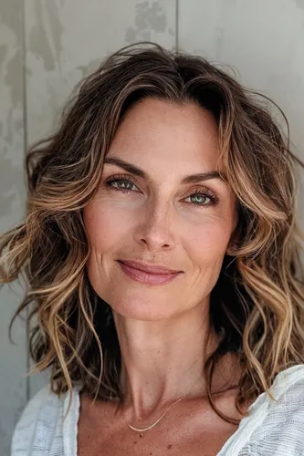 Try on this wavy, medium-length hairstyle that gently frames the face, adding a soft, feminine touch.