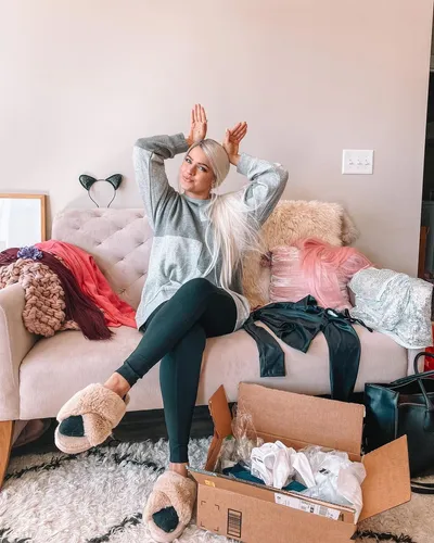 Try on this long straight hairstyle, featuring a shiny, platinum blonde look. The woman has her hair pulled back into a high ponytail, accentuating the sleekness of the straight strands.