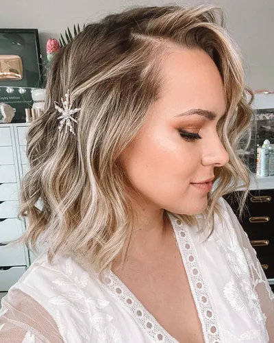 Try on this elegant shoulder-length wavy hairstyle, highlighted with a chic star-shaped hair accessory adding a touch of glam.