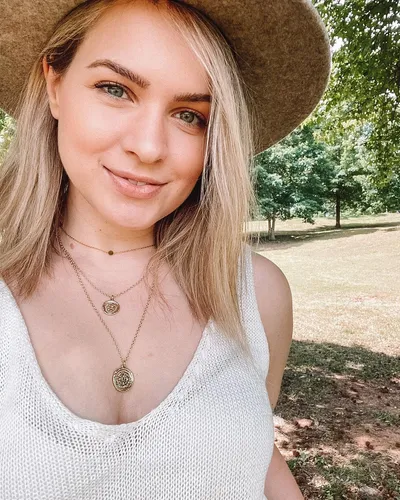 Try on a straight, blonde hairstyle like the woman in the image, paired with a casual outdoor setting. This hairstyle exhibits soft, straight textures and a light blonde color, suitable for various occasions and complementing a relaxed, stylish look.