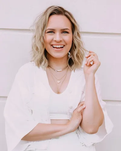 Try on this medium length wavy hairstyle, which is styled loosely to frame the face, giving a casual and stylish look.