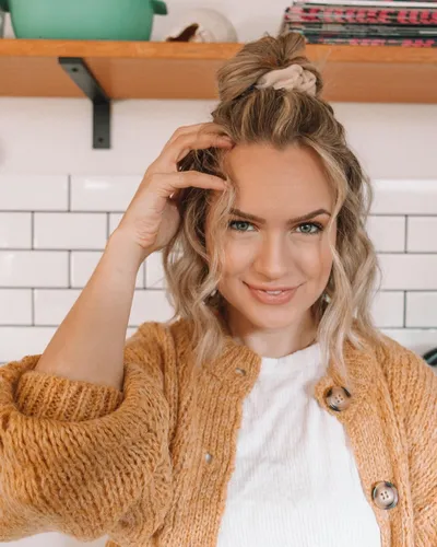 Try on a hairstyle featuring a high messy bun with a braided detail, adding a casual yet charming touch.