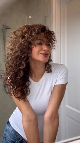 Try on this hairstyle featuring long, voluminous curly hair, cascading in rich curls.