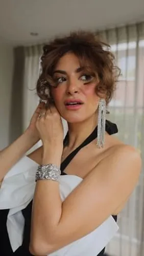 Try on a curly, short hairstyle that frames the face with voluminous curls, adding a playful yet elegant twist.