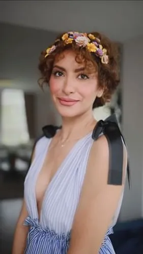 Try on this curly hairstyle adorned with a colorful floral headband.