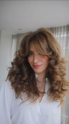 Try on this voluminous curly hairstyle featuring rich, flowing curls framing the face, perfect for a fresh and lively look.