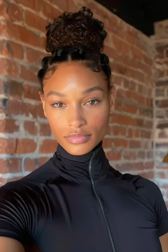 Try on a curly updo hairstyle gathered at the top with braided details at the front.