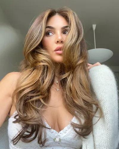 Try on this long wavy hairstyle, showcasing a mix of light and dark brown tones, flowing down and styled to enhance the hair’s natural volume and texture.