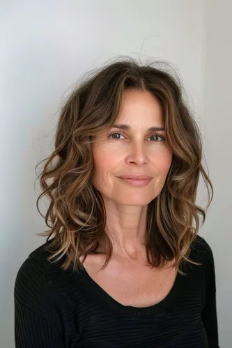 Try on this medium-length wavy hairstyle, featuring brown highlights and soft, cascading curls that frame the shoulders.