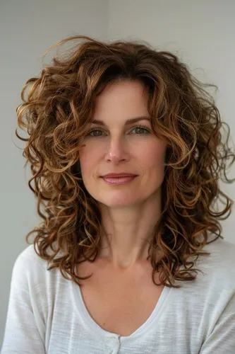 Try on this stylish curly hairstyle featuring voluminous light brown curls