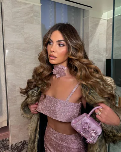 Try on this long wavy hairstyle that cascades elegantly on the shoulders, highlighted with light brown and blonde tones that enhance the wave patterns, presenting a voluminous and glamorous look.