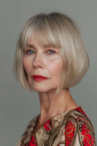 Try on a stylish blonde bob haircut that frames the face with eyebrow-length bangs, providing a fresh and elegant look.