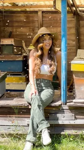 Try on this long, wavy hairstyle paired with a casual straw hat. This hairstyle exudes a playful and carefree vibe, perfect for a sunny outdoor setting.