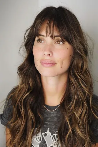 Try on this hairstyle featuring long wavy hair with face-framing bangs, giving a playful and voluminous look.