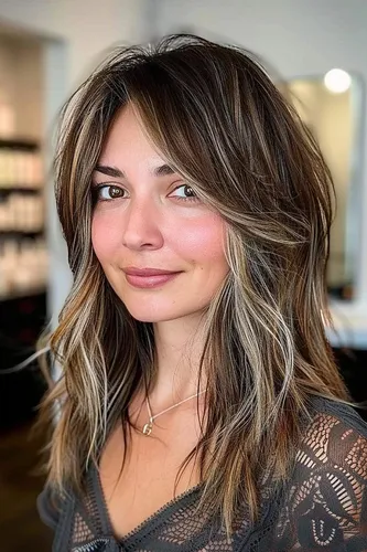 Try on this shaggy, layered haircut featuring textured waves that gracefully frame the face. The rich brown roots with light brown and blonde highlights create a vibrant, dimensional look, perfect for a fresh, modern style.