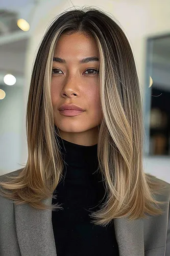 Try on this stylish hairstyle featuring long hair with smooth blonde highlights, styled straight with a slight curl at the ends for a sleek and modern look.