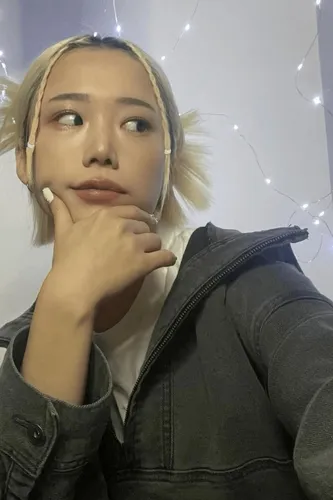 Try on a blonde ponytail hairstyle with strands loosely framing the face, seen from a side angle