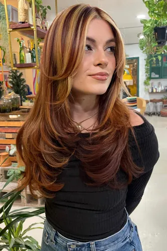Try on a multi-colored layered hairstyle, featuring shades of brown, auburn, and blonde, cascading in soft waves