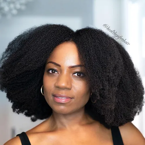 Try on a voluminous afro hairstyle with tight curls presenting a natural and dense texture