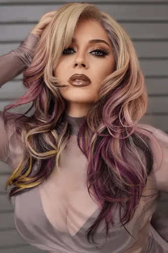 Try on this voluminous multi-colored hairstyle with wavy locks in shades of blonde, purple, and hints of yellow, styled to flow beautifully around the face.
