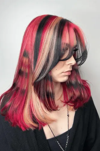 A try on of a vibrant medium-length hairstyle featuring black and red colors, giving an edgy and bold appearance.