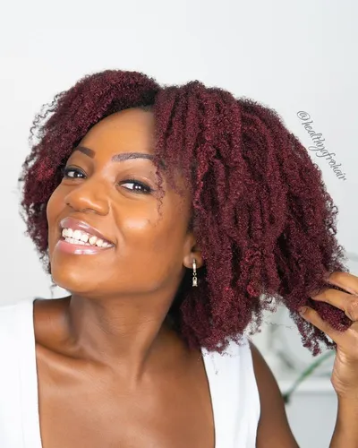 Try on a vibrant dyed curly hairstyle as shown on the cheerful woman