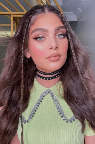 Try on this hairstyle featuring long wavy brown hair with sections braided on either side, providing a playful yet chic look.