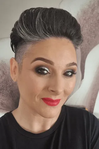 Try on this modern and stylish slicked back hairstyle, perfectly coupled with a short cut on the sides. The hint of gray roots adds a sophisticated touch.
