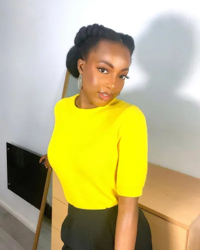 try on a braided bun hairstyle, neatly styled atop the head.