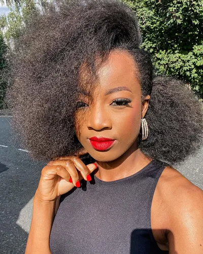 Try on this voluminous afro hairstyle, which features a large, fluffy texture that frames the face symmetrically.