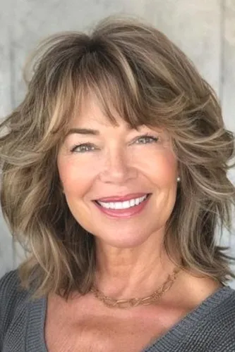 Try on this lovely layered hairstyle with soft bangs, suitable for enhancing facial features with a soft, voluminous look.