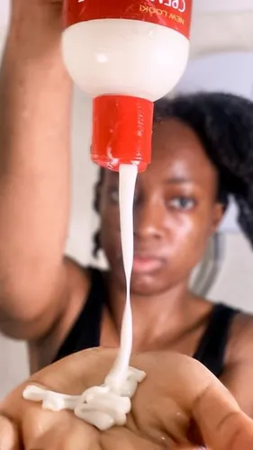 Try on a short hairstyle visible on a person holding a bottle, squeezing a creamy product into their hand