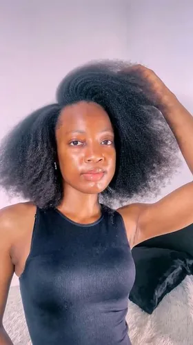 Try on the afro hairstyle in this image, showcasing thick, voluminous hair texture