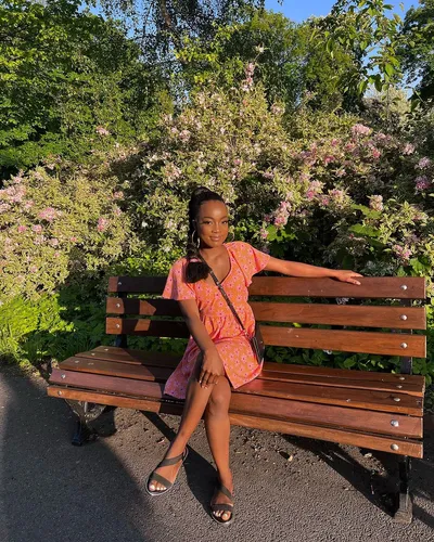 Try on a sleek, braided hairstyle as depicted by the woman sitting on the park bench.