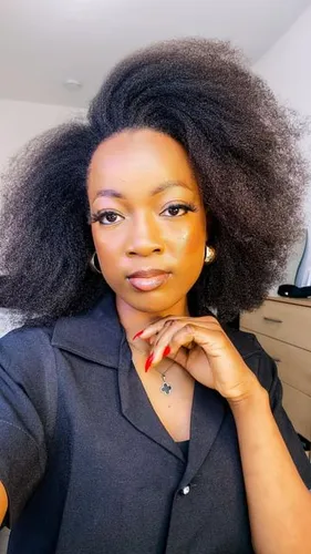 Try on this voluminous afro hairstyle, featuring densely packed, textured curls that expand outward, creating a striking and bold silhouette.