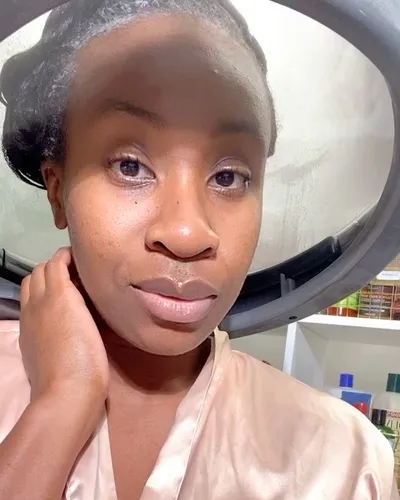 Try on this salon-style where the voluminous, dark hair is tied back, partially covered under a dryer in a beauty salon setting.