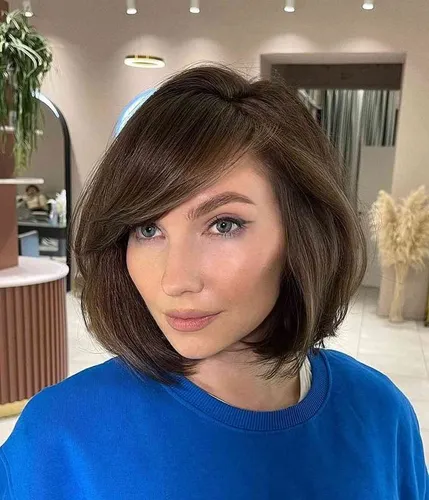 Try on this tidy and sculpted short bob hairstyle which elegantly frames the face with its soft, wavy layers and subtle volume.