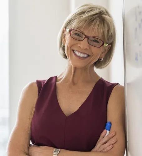 Try on a cheerful style featuring a woman with a short, layered blonde hairstyle, giving a vibrant and professional appearance.