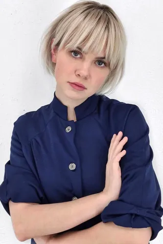 Try on a trendy bob cut with blonde hair and bangs, featuring a light tone with darker roots.