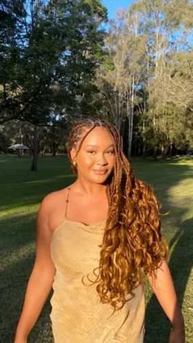 Try on this hairstyle featuring braided roots transitioning to long, flowing wavy hair.