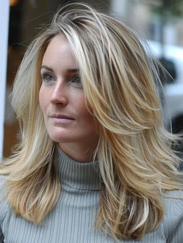 Try on this blonde wavy hairstyle that flows generously with soft waves and subtle blonde highlights, perfect for a casual yet stylish look.