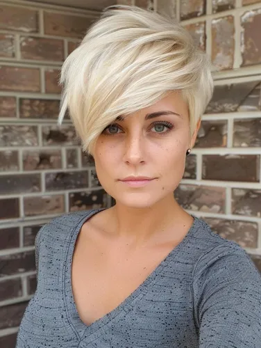 Try on this stylish short blonde hairstyle, featured as a chic pixie cut with layered strands that elegantly outline the head shape.