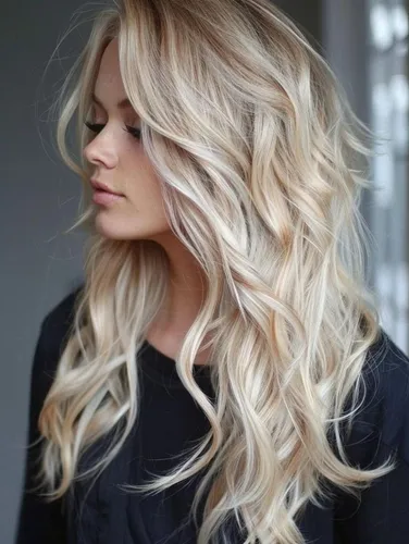 Try on this long, wavy blonde hairstyle that features soft, flowing curls and lighter highlights, creating a dimensional and voluminous look.