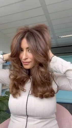 Try on this glamorous long curly hairstyle with highlighted strands adding depth and dimension.