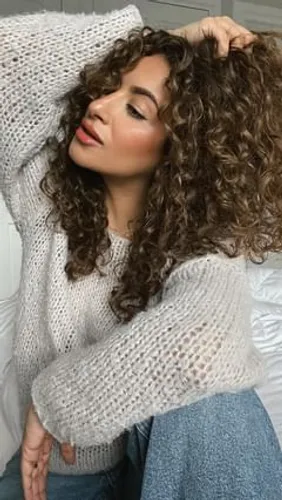 Try on this voluminous curly hairstyle, featuring defined, bouncy curls that add a playful touch to any look.
