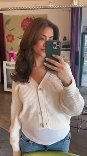 Try on this elegant wavy, medium-length hairstyle that gracefully frames the face with volume and movement.